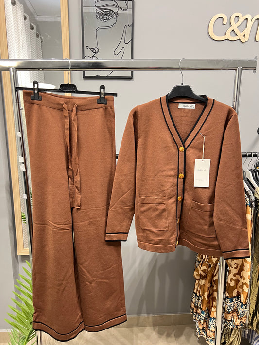 Καφέ πλεκτό σετ με ζακέτα V-neck και φαρδύ παντελόνι κρεμασμένο σε κρεμάστρα. Vintage στυλ με σκούρες ρίγες στα τελειώματα, χρυσά κουμπιά και δύο τσέπες. One size fits XS-L"